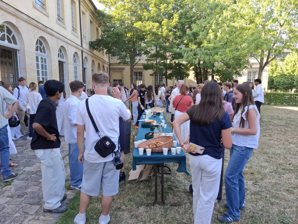 Des jeunes autour d'un buffet dans un jardin